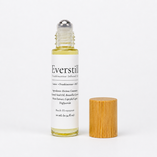 Everstill Frankincense & Myrrh roll-on oil featuring a stainless steel roller ball with bamboo cap beside the bottle.