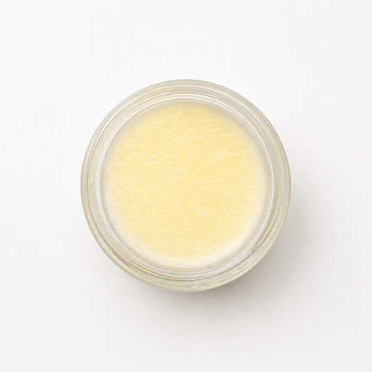 An flat lay photo of an open jar of tallow balm